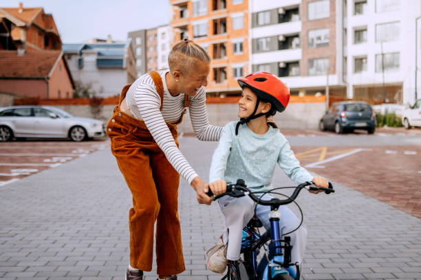 istock Mother teaching her daughter how to ride bicycle 2182079423