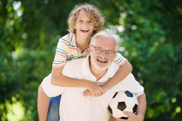 istock Grandfather and kids in sunny garden 2182080296