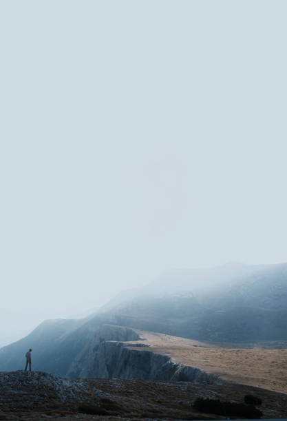 Photo of a hiker enjoying his achievement and taking a rest at the mountain peak, surrounded with  beautiful nature