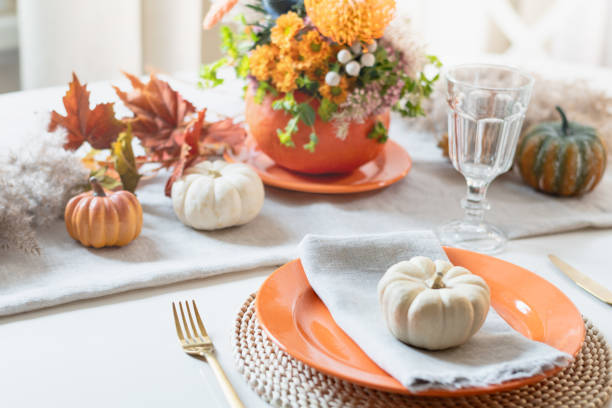 istock Thanksgiving day table setting with fall decorations of flowers and pumpkin. 2182086414