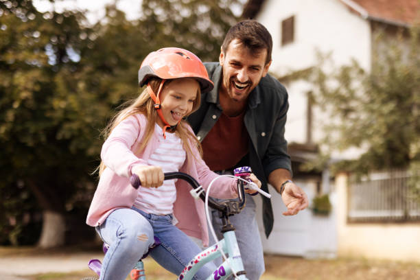 istock Caring Father Teaching His Small Daughter Bicycle Riding 2182089386