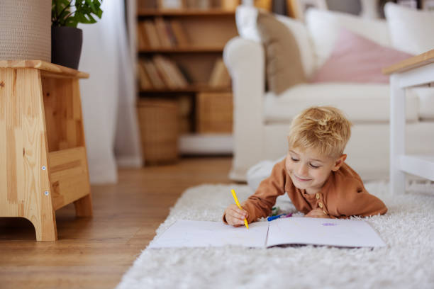 istock Little Boy Drawing With Felt-tip Pen on Floor at Home 2182089516