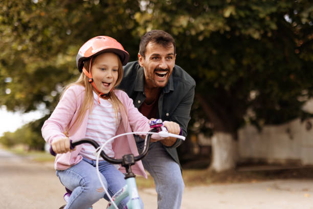 istock Caring Father Teaching His Small Daughter Bicycle Riding 2182089587