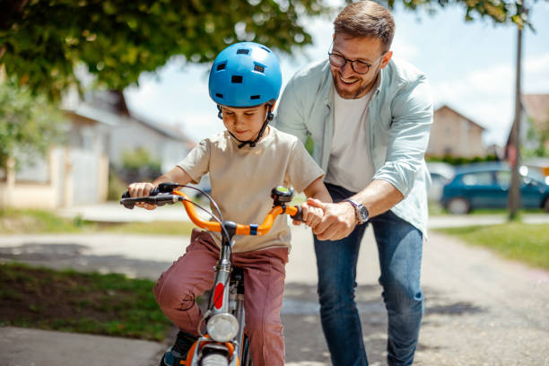 Joyful Father Help His Cute Little to Son Ride a Bicycle