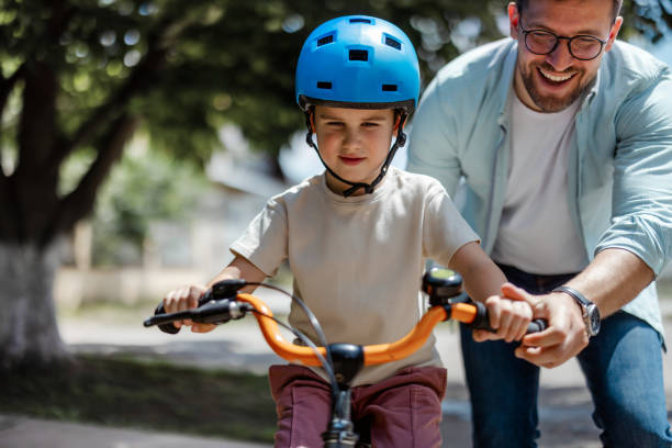istock Joyful Father Help His Cute Little to Son Ride a Bicycle 2182089717