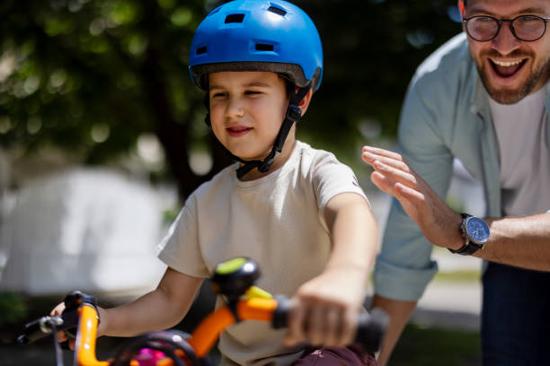 istock Joyful Father Help His Cute Little to Son Ride a Bicycle 2182089801