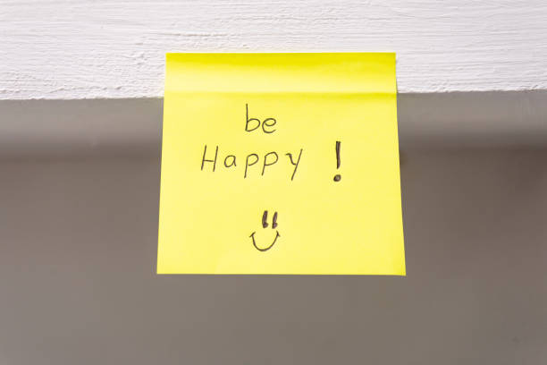 Yellow sticky note with the phrase Be happy written on it