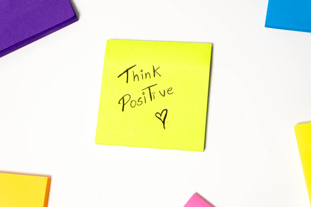 istock Think positive written on sticky notes isolated on white background with copy space 2182090530