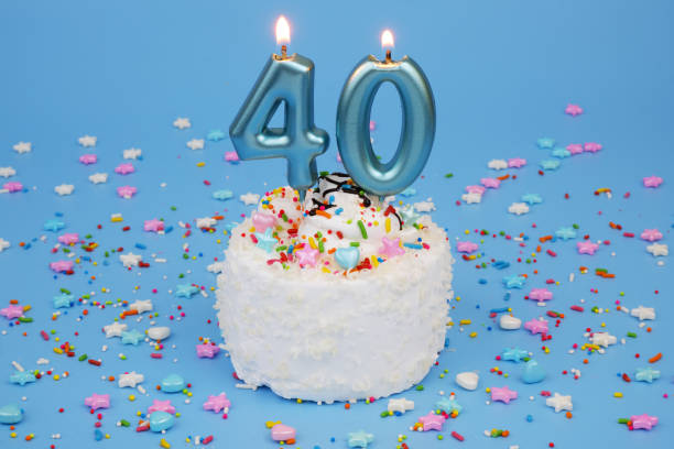 istock Coconut birthday cake on blue background with burning candles, number 40 2182092092