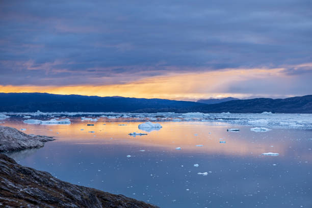 Ice floating on the Eqi fjord in a sunset outside Ilulissat in western Greenland which is an UNESCO World Heritage Site due to the Ice Fjord