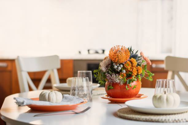 istock Thanksgiving day table setting decoration centerpieces with flowers in pumpkins. 2182093010