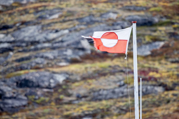 Small and worn Greenlandic flag in stormy weather outside Ilulissat in western Greenland which is an UNESCO World Heritage Site due to the Ice Fjord