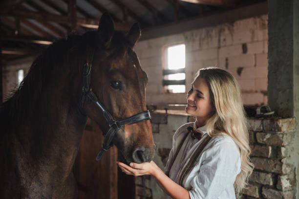 istock Tender Moment Between Woman and Horse in Stable 2182103998
