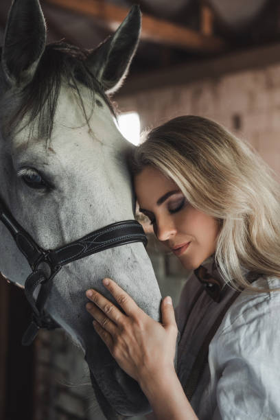 istock Tender Moment Between Woman and Horse in Stable 2182104251
