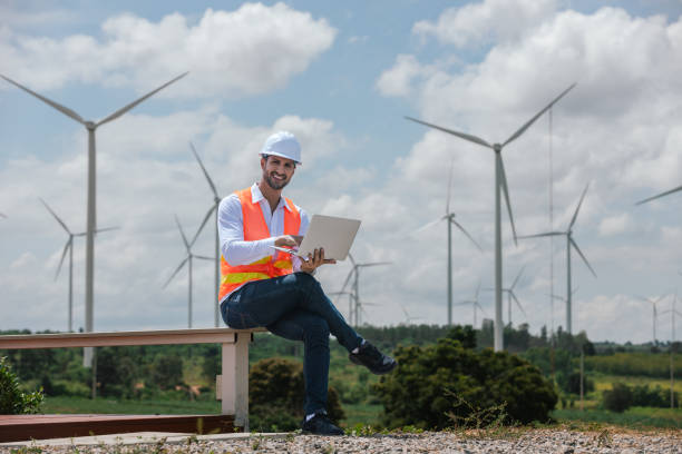 istock Engineer wearing safety uniform holding laptop discussed plan about renewable energy at station energy power wind. technology protect environment reduce global warming problems. 2182104584