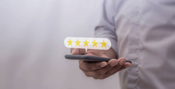 istock Customer Review, Young Man hand using smartphone mobile with five star to review and give 5 stars with very good results in service, Good review 5 star rating choice feedback 2182104773
