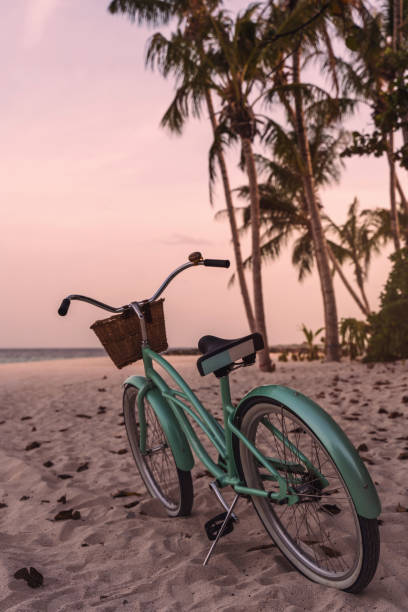 A young woman relaxes on a small beach in front of the sea during a bike ride along the sea.