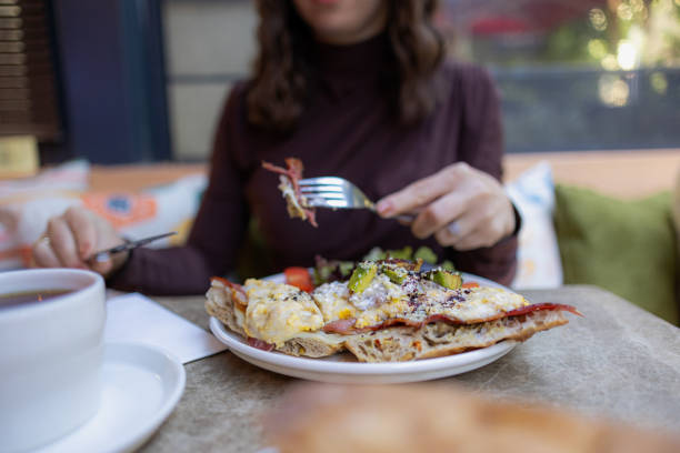 istock Brunch plates at a restaurant, fork and knife in hands 2182112948
