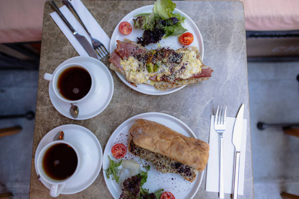 istock Brunch plates at a restaurant, fork and knife in hands 2182113056