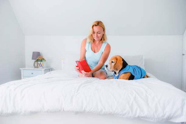 istock woman and her dog watching iphone 2182114893