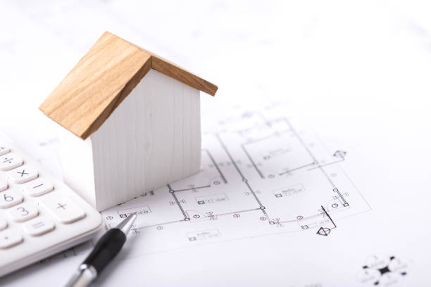 istock Concept of budgeting for home construction, with a house model, calculator, and construction plans placed on a table, symbolizing financial planning for building a home 2182117854