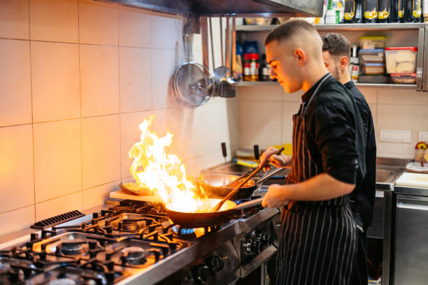 istock Chef And Sous-Chef Cooking With Fire In A Commercial Kitchen 2182118035