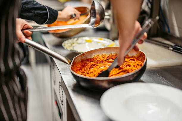 istock Chef And Sous-Chef Making Bolognese Pasta In A Commercial Kitchen 2182119077