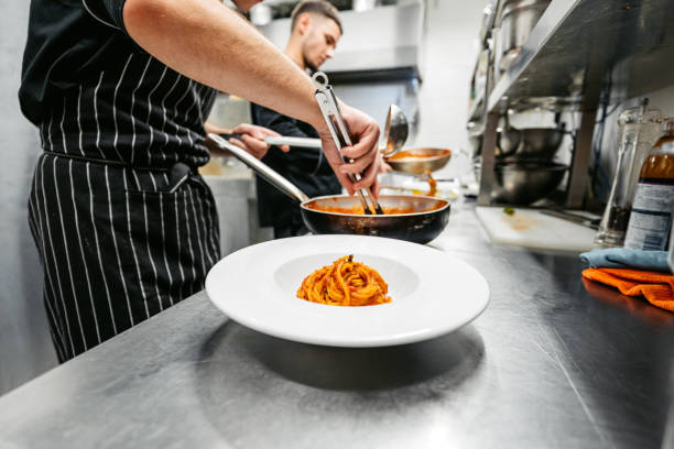 istock Chef And Sous-Chef Making Bolognese Pasta In A Commercial Kitchen 2182119328