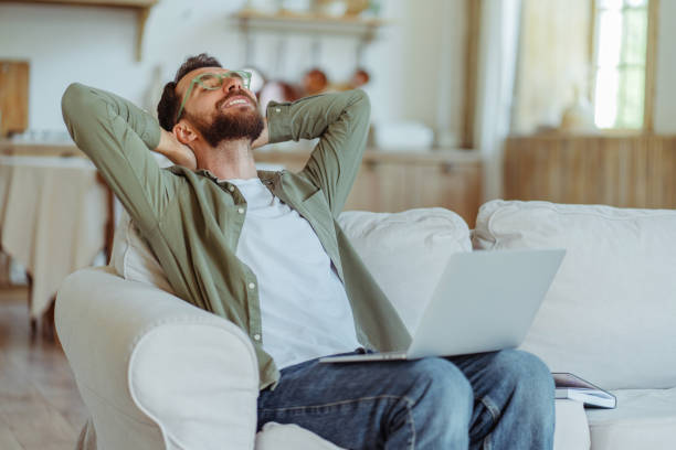 istock Freelancer relaxing on sofa with laptop after finishing work 2182119367