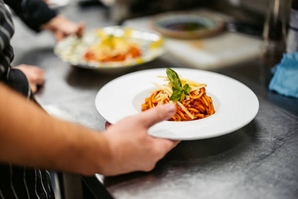 istock Chef And Sous-Chef Making Bolognese Pasta In A Commercial Kitchen 2182119790