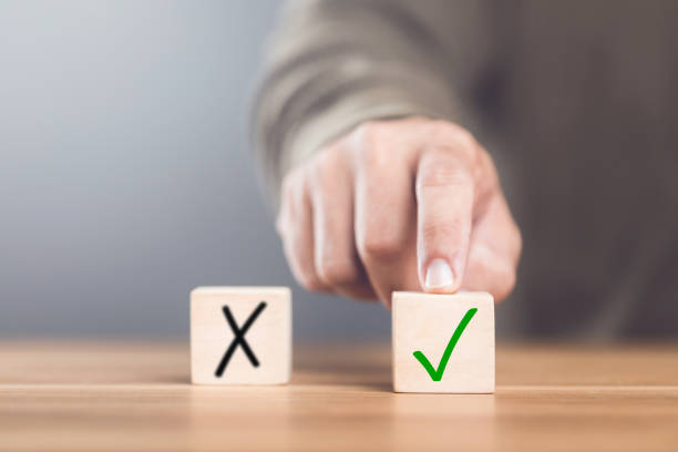 istock A man choosing between a checkmark and an 'X' symbol on wooden blocks. Image represents the concept of making the right choice, highlighting the importance of distinguishing between right and wrong 2182119856