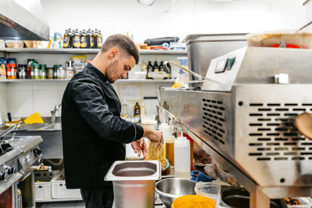 istock Young Chef Making Pasta In A Commercial Kitchen 2182120822