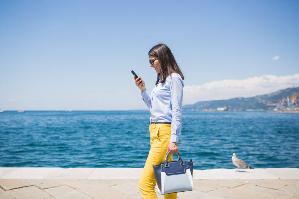 istock Young Woman Using Smartphone by the Seaside 2182120936