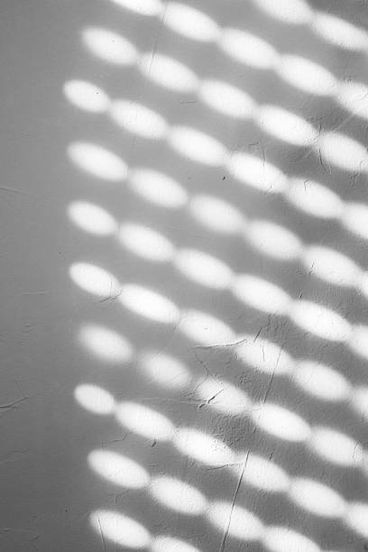istock Blurred light spots, shadows from the blinds on the concrete wall on a sunny day, Natural shadow pattern on a textured white wall, formed by filtered sunlight. Copy space 2182121037