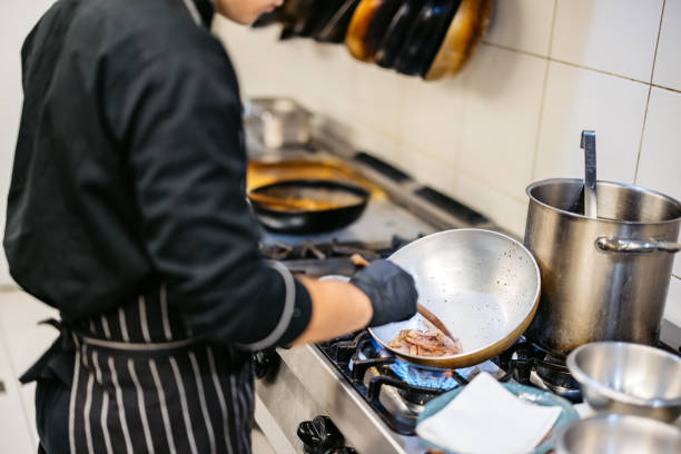istock Young Chef Cooking With A Pan In A Commercial Kitchen 2182121052