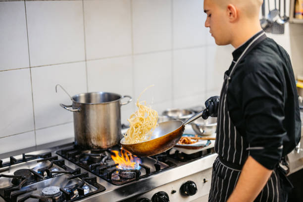 istock Young Chef Making Pasta In A Commercial Kitchen 2182121273