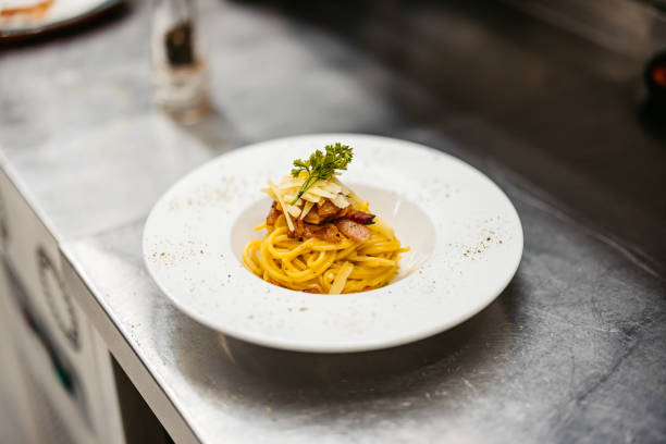 Pasta carbonara on the counter in a commercial kitchen. Close-up.