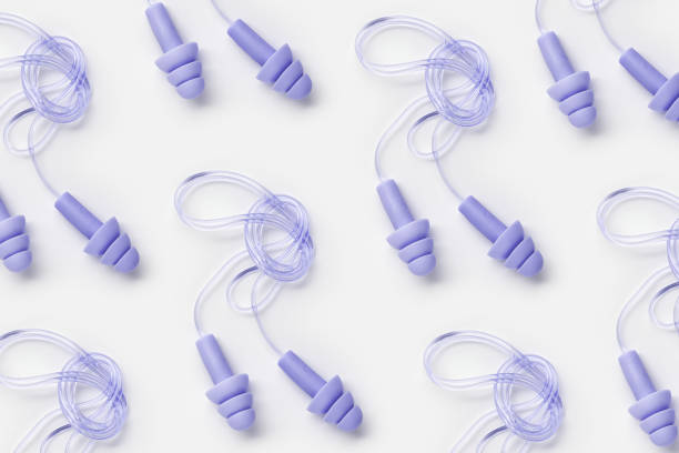 istock Reusable silicone violet color earplugs, for swim, sleep, rest as minimal trend pattern on white background. Soft, flexible ear plug on cord against noise, protect hear, top view, flat lay 2182121499