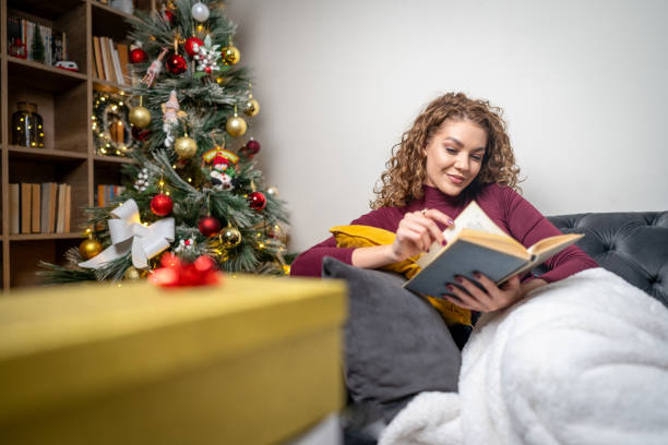 istock Woman enjoying reading an interesting book on Christmas 2182127353