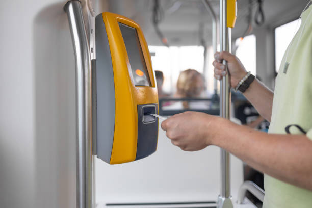 istock Yellow ticket validation machine on a modern public transport bus. Traveler validating train ticket at terminal. Modern prepaid public transport ticketing system with validation machine at entrance of bus. 2182127514
