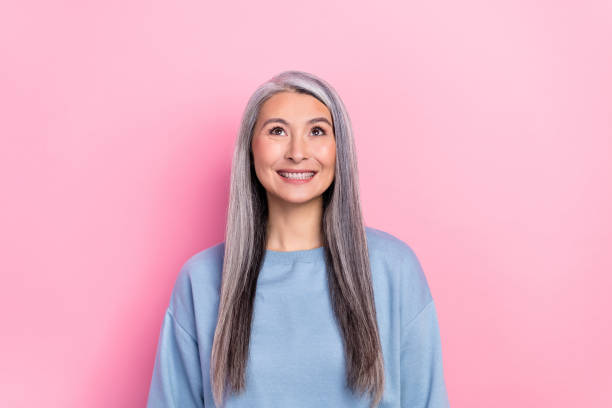 istock Photo of dreamy shiny lady pensioner dressed blue pullover looking up empty space isolated pink color background 2182132214