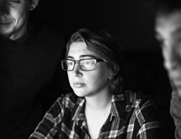 istock Three young people concentrating on a computer, reflected in the woman's glasses 2182133122