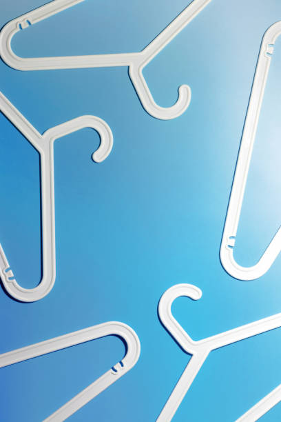 istock White Plastic hangers as abstract minimal frame on soft blue gradient background, Clothes rack for organizing clothes in closets or retail stores for hanging of garments, top view, copy space 2182135880