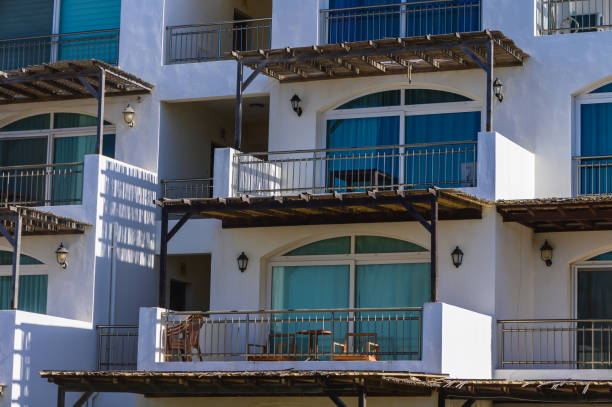 A tall building with many balconies and windows. The balconies are all facing the same direction, and the windows are all of the same size. The building appears to be a hotel or apartment complex