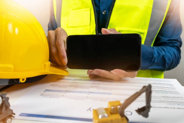 istock A mobile mockup where an engineer holds up a screen to insert graphics or text. 2182148734
