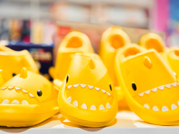 The image presents a display case filled with fish-shaped sandals, each one showcasing a unique color.