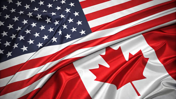 Close-up of the United States and Canadian flags waving together, symbolizing friendship and partnership between the two nations. Represents diplomatic relations and international cooperation.