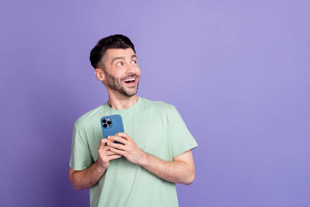 istock Photo of young man device look copyspace instagram telegram twitter facebook dressed stylish gray look isolated on purple color background 2182152475