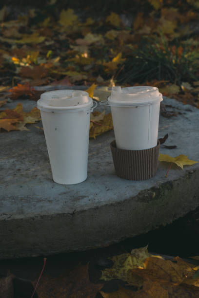 istock Two paper coffee cups stand on a concrete slab. Minimalism coffee cups 2182152652