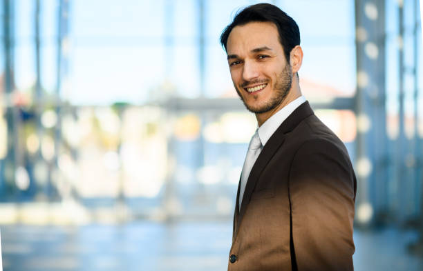 istock Young businessman smiling at the camera in a modern office building 2182153720